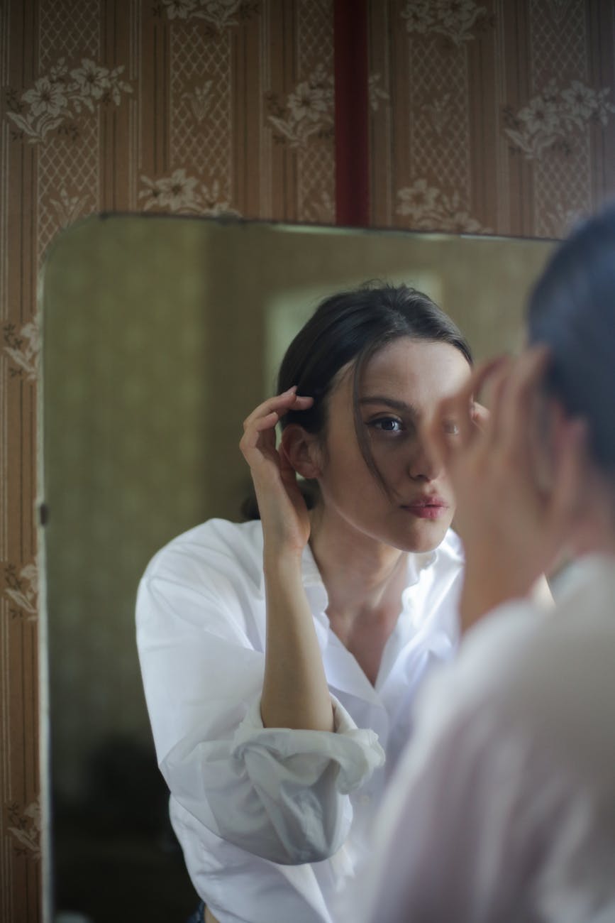 woman in white dress shirt holding her face